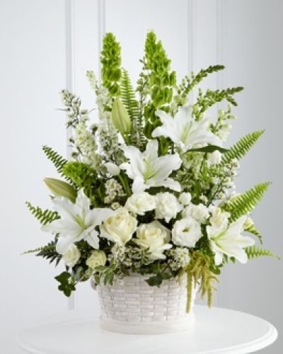 <p>This thoughtfully composed tribute includes white roses, tulips, freesia, Oriental lilies, double lisianthus, monte casino asters, and snapdragons. The flowers are artfully arranged in a large round whitewash basket, making it a fitting choice for memorial services, funerals, or for sending directly to a loved one’s home.</p>