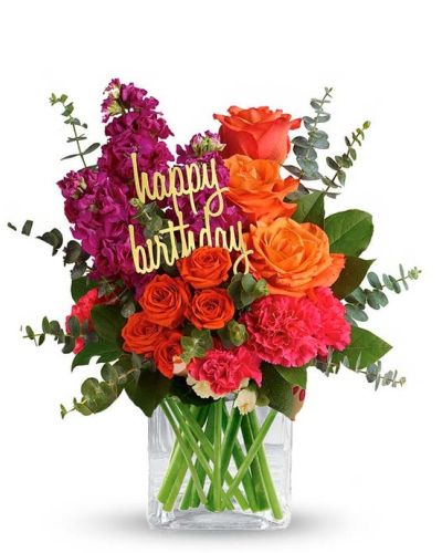 <p>This bouquet features a spirited mix of orange roses, orange spray roses, and pink carnations, arranged with care in a sleek glass cube vase. The cube vase gives it a contemporary flair while keeping the focus on the blooms.</p>